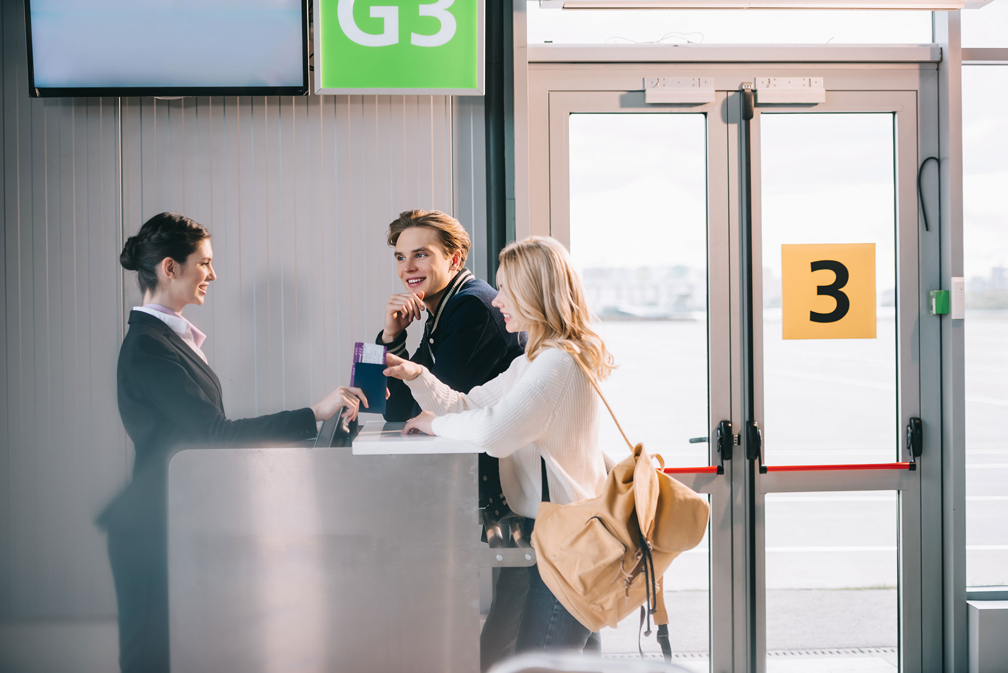 Side view of happy young couple at check-in desk